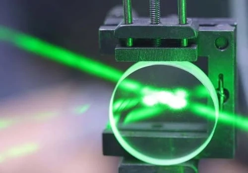 green laser reflecting on a plane window